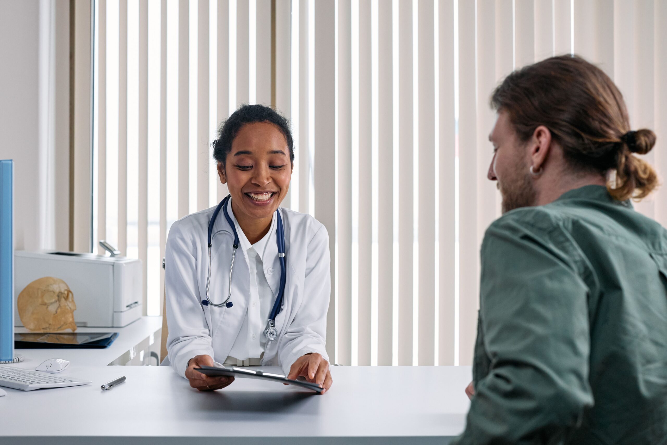 Medico conversando com paciente durante consulta em clinica, contexto de acompanhamento medico e plano de saude