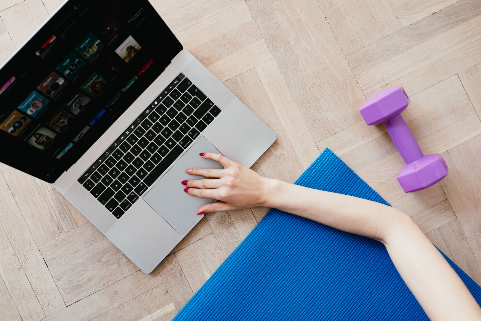 Tapete de yoga, halteres e notebook representando rotina de treino em casa