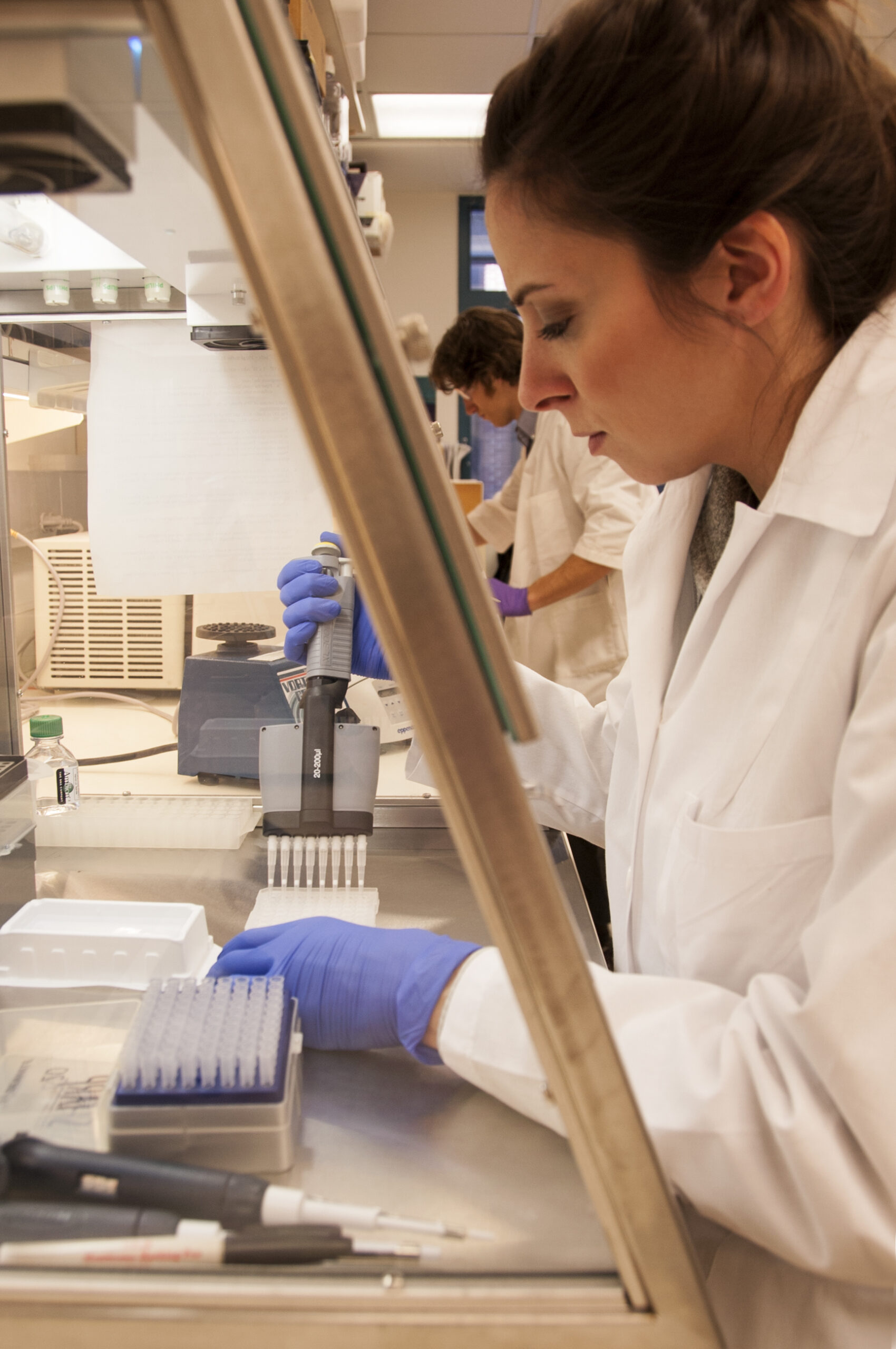 Pesquisadora trabalhando em bancada de laboratório